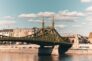 Sunlit Liberty Bridge in Budapest spans the Danube, showcasing urban architecture and cityscape.